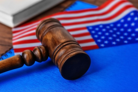 Notebook, gavel and American flag on table