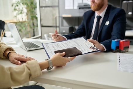 Close up of woman applying for visa in US immigration office and handing documents